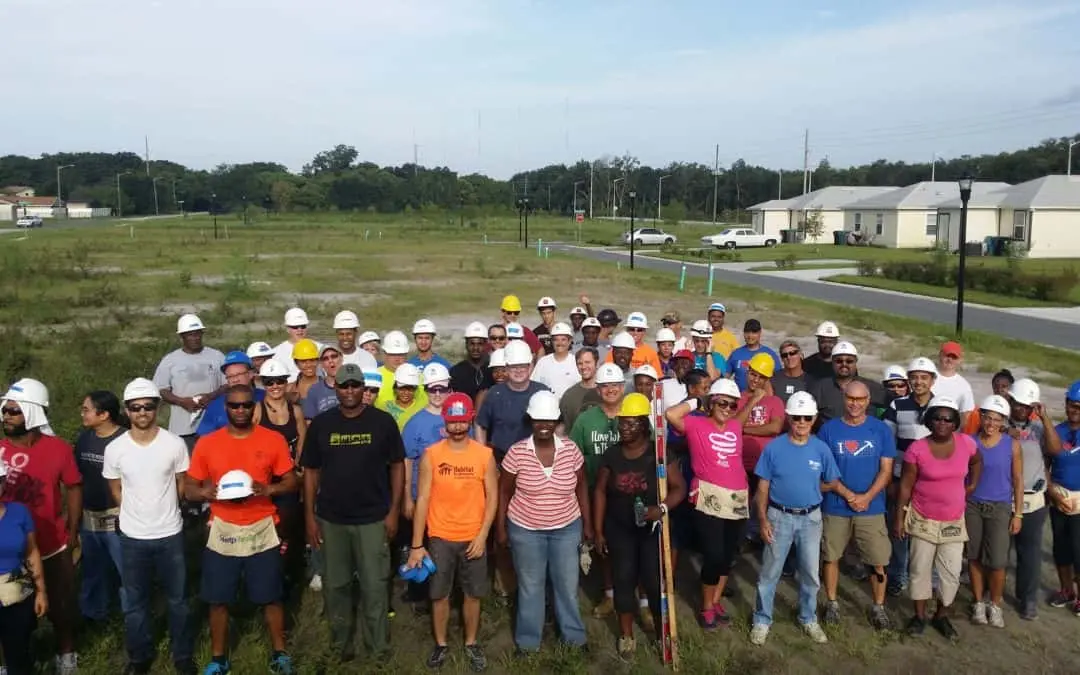 A crowd of Habitat volunteers pose for a photo.