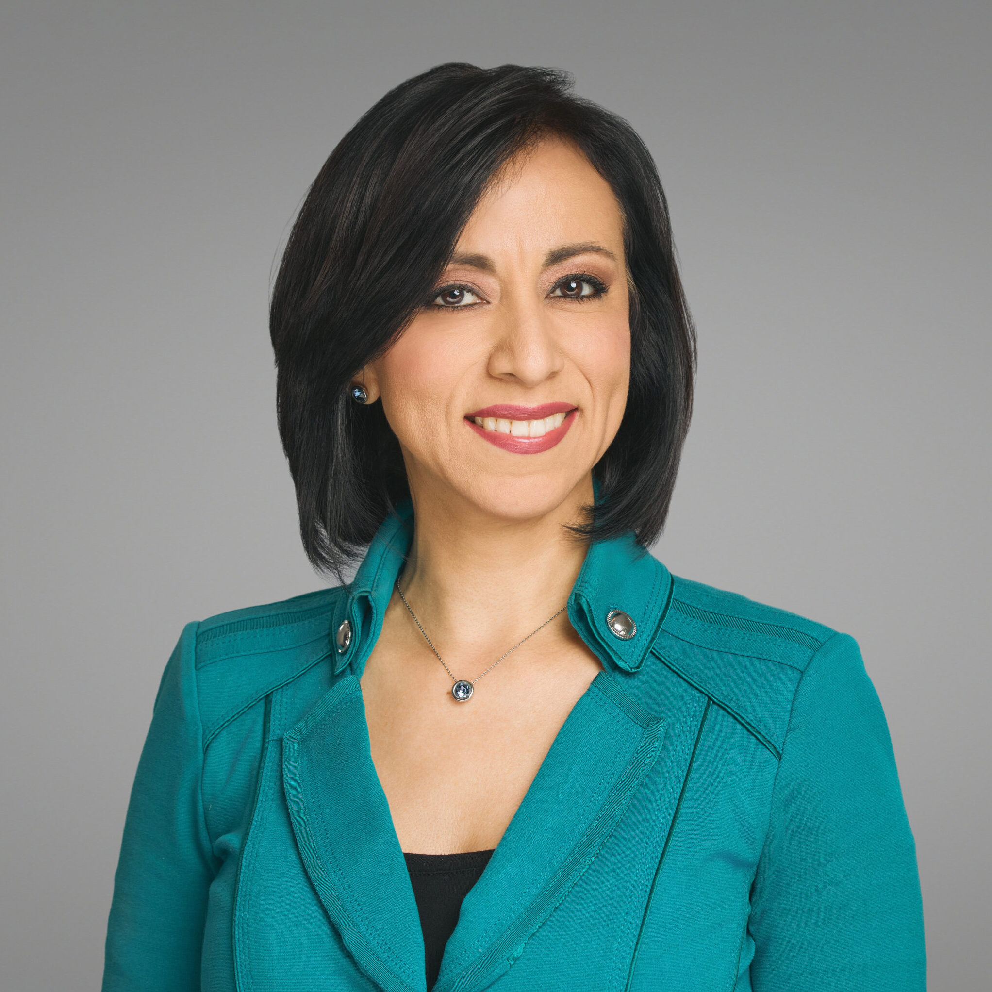 Business woman smiling at camera in front of white background