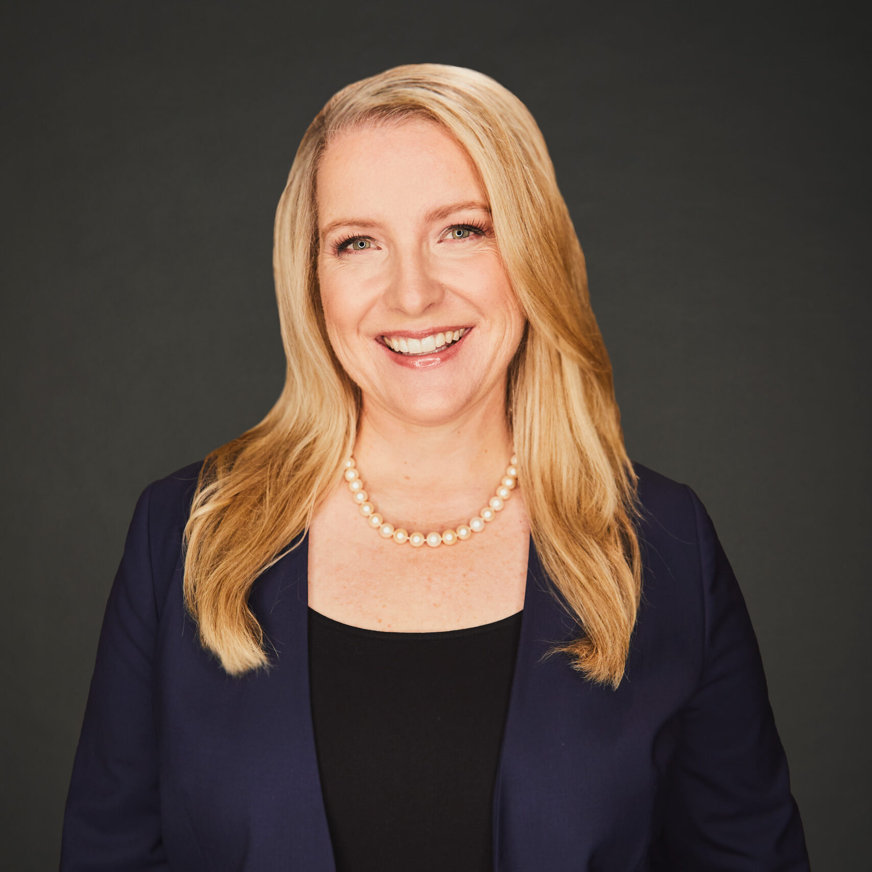 Business woman smiling at camera in front of white background