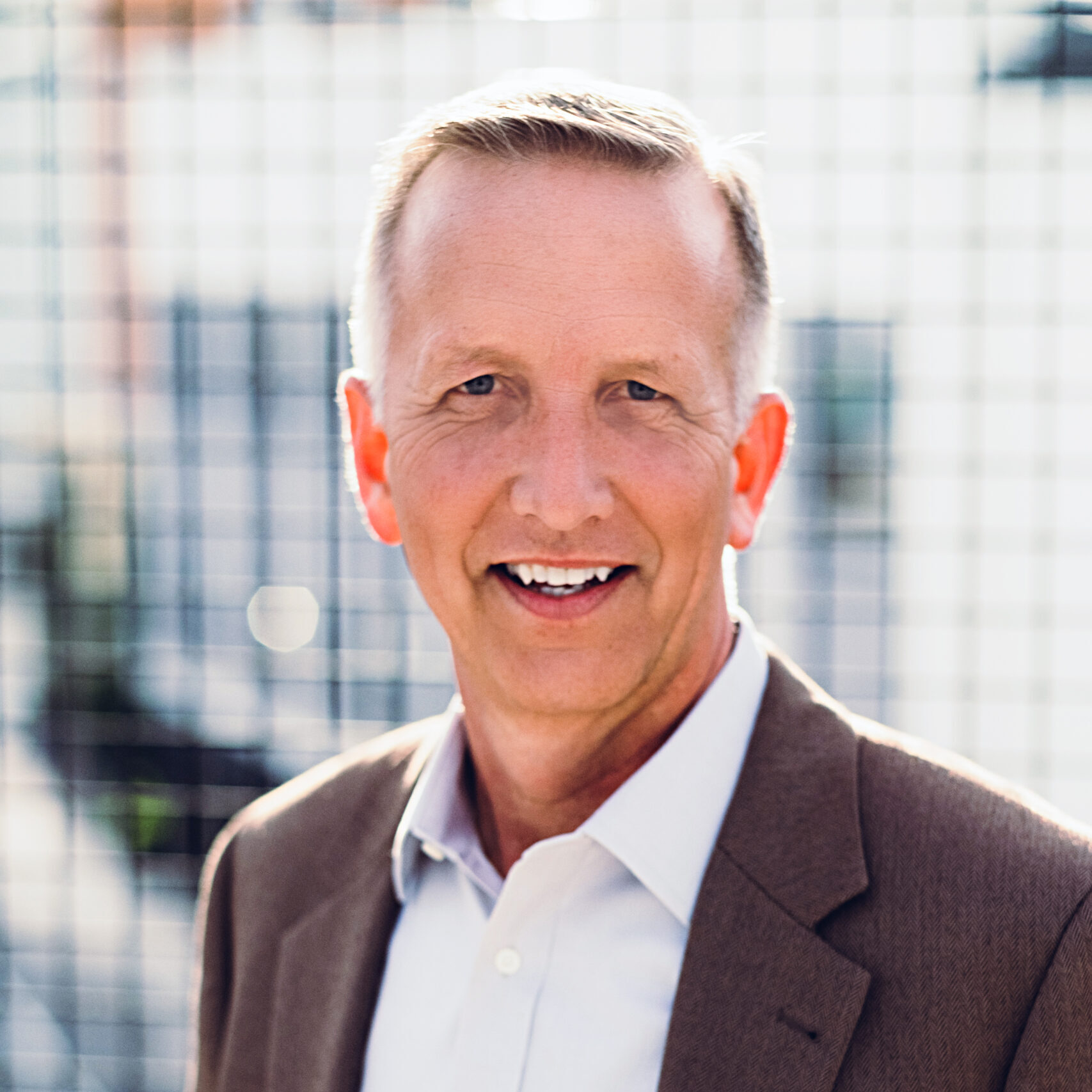 Business man smiling at camera in front of white background