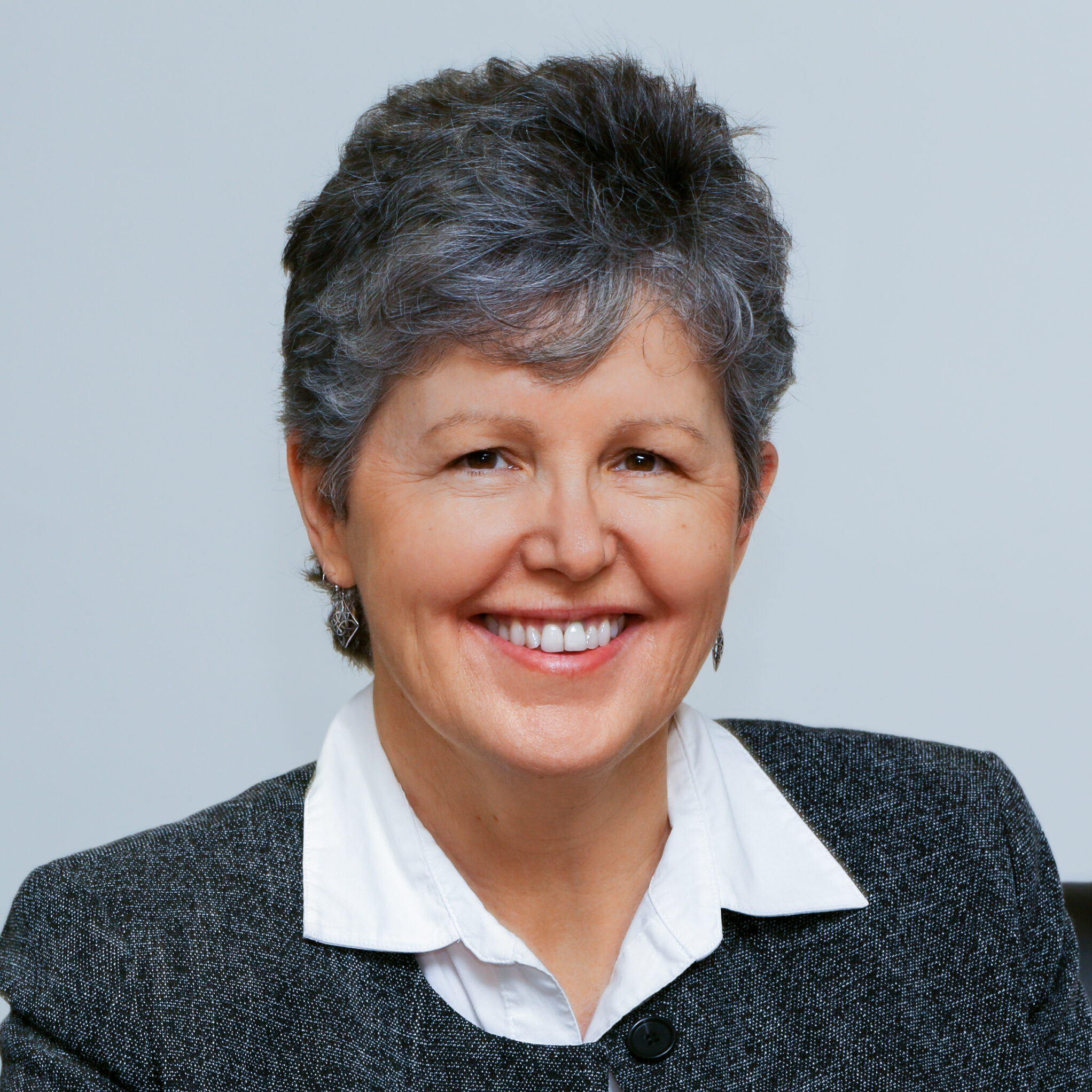 Business woman smiling at camera in front of white background