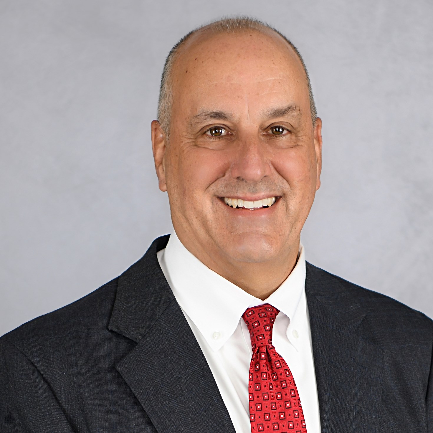 Business man smiling at camera in front of white background